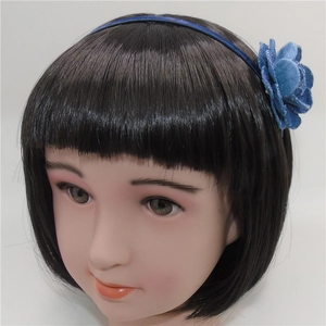 Detalle de una diadema con flor de camelia de terciopelo azul para niñas en fondo blanco