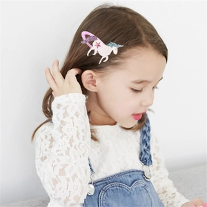 Dettaglio molletta per capelli a forma di unicorno con corno glitterato su bambina