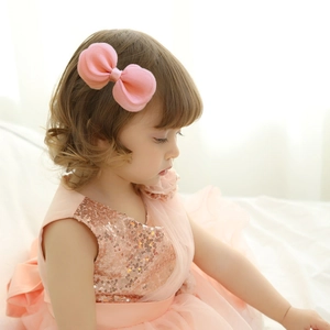 Vue détaillée d'une barrette à nœud en tulle rose pour enfant portée par un modèle