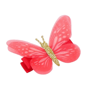 Dettaglio del fermaglio per capelli a farfalla in chiffon rosso con glitter oro