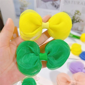 Gros plan de barrettes à cheveux avec nœuds en tulle multicouche jaune et vert fluo