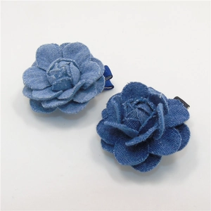 Vista detallada de las pinzas de pelo de camelias en tela denim azul oscuro y claro