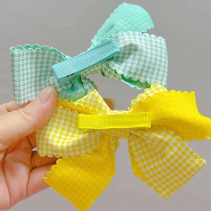 Détail de nœuds en tissu à carreaux avec bords festonnés et pinces crocodiles