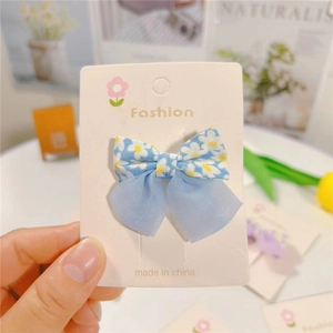 Detailed macro view of the double-layer floral bow hairpin with elegant chiffon ribbons