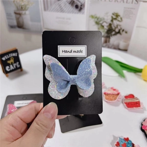 Détail d'une pince à cheveux papillon faite main avec paillettes bleues et violettes