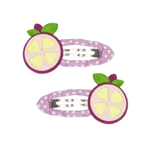 Dettaglio di due fermagli per capelli viola a pois con motivi di frutta e glitter fini