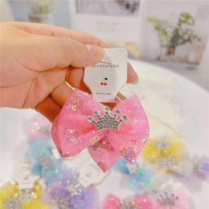 Pink tulle bow hair clip with rhinestone crown detail for kids on white card