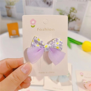 Floral bow hair clip featuring purple daisy patterns and sheer organza fabric layers