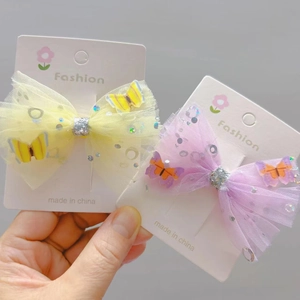 Detail of sequined mesh bow hair clips with 3D butterfly motifs on white display cards
