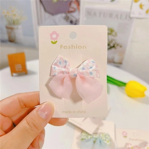 Detailed view of a sweet floral bow hair clip with double-layer pink mesh and fabric floral pattern