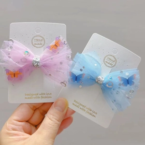 Detail of pink and blue sequined mesh bow hair clips with 3D butterfly ornaments