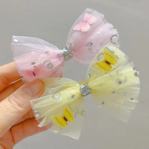 Detail of pink and yellow mesh hair clips with shiny sequins and 3D butterfly accents