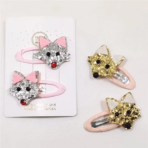 Détail de quatre barrettes renard fait main avec paillettes sur support en tissu rose
