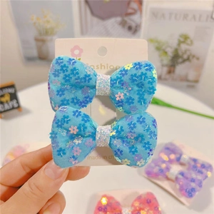 Paio di fermagli per capelli blu con paillettes floreali per bambine su carta moda
