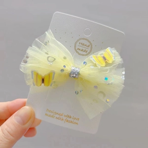 Handmade yellow mesh bow hair clip with 3D butterflies on a white card display