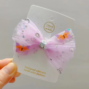 Close-up of handmade lavender tulle bow hair clip with 3D butterflies and sequins
