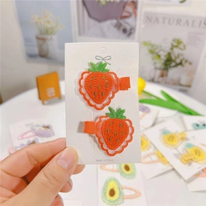 Cute strawberry embroidered hair clips for kids on a decorative white display card