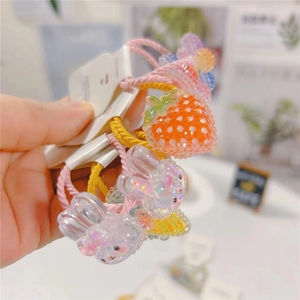 Detail of pink and yellow spiral hair ties with glittery rabbit and flower charms