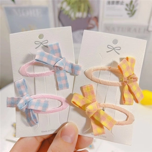 Close-up of 4-piece set fabric bow hair clips with plaid patterns on display cards