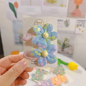 Gros plan de barrettes fleurs bleues faites à la main avec paillettes et motif floral doux
