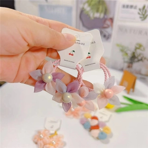 Détail de chouchous à fleurs en seersucker et perles pour filles en tons pastel doux