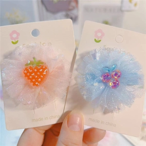 Détail des pinces à cheveux fleurs en maille arc-en-ciel avec ornements fruits en résine