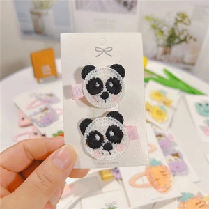 Close-up of cute panda embroidered hair clips with pink fabric wrapped metal clips