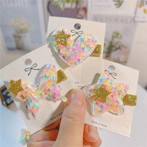 Close-up of glitter sequins heart, butterfly, and star hair clips on display card