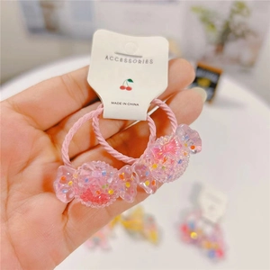 Close-up of pink elastic hair ties with glitter resin candy charms on paper card