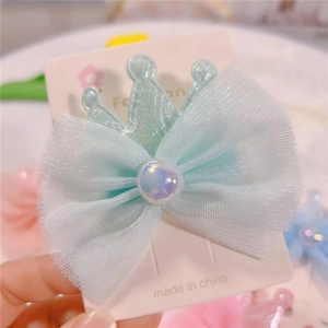 Detail of mint green gauze bow hair clip with pearlescent crown and colorful pearl