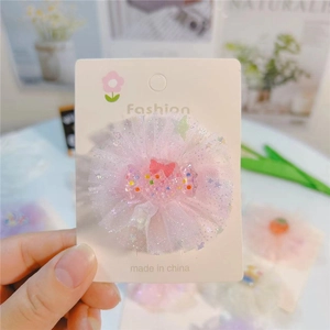 Détail de la pince à cheveux bonbon en tulle rose avec n\u00f3eud en acrylique sur carte