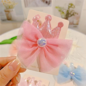 Detailed view of a pink crown glitter hair clip with soft tulle bow and a faux pearl