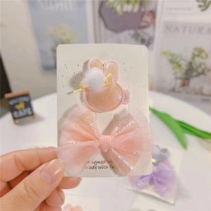 Ensemble de pinces à cheveux lapin rose et nœud scintillant sur carte d'exposition