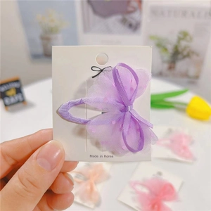 Purple tulle bow hair clip with polka dots on white display card for girls