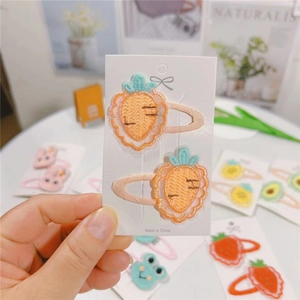 Detail of embroidered carrot hair clips set on cardstock for girls' hair accessories