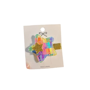 Colorful sequined star hair clip with gradient stripes and golden star center detail