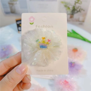Détail d'une pince à cheveux fleur en résille blanche avec couronne pailletée