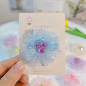 Détail de la barrette fleur en maille bleu clair avec breloque cerise violette brillante