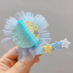 Détail de la barrette en tulle bleu avec étoile scintillante et étoiles pailletées
