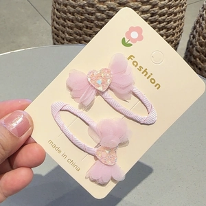 Close-up of pink chiffon bow hair clips with glittery heart detail for girls