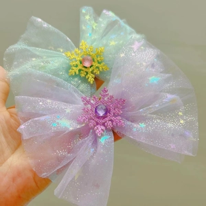 Close-up of mesh bow hair clips with glitter stars and jeweled snowflake ornaments