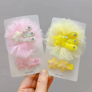 Détail des barrettes étoiles faites main avec fleurs en tulle et sequins brillants
