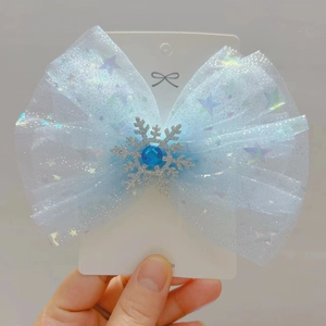 Detail view of ice blue lace mesh bow hair clip with silver snowflake and gem decoration