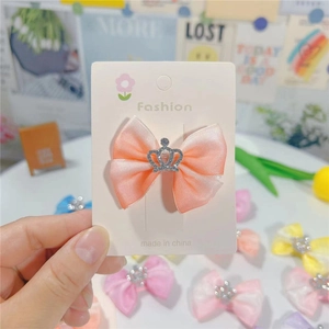 Nœud de cheveux en satin rose avec strass couronne argentée sur carte d'exposition