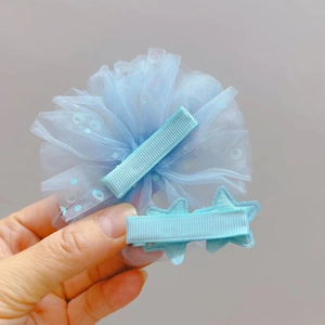 Détail d'un ensemble de deux barrettes bleu clair avec paillettes et doubles étoiles