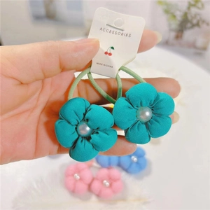 Gros plan sur des élastiques à fleurs vertes en peluche avec perles pour filles