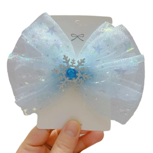 Blue tulle hair bow with golden snowflakes and blue gemstone on display card