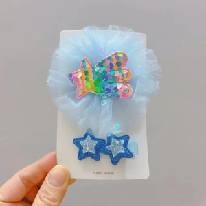 Détail d'une pince à cheveux fleur en résille bleue et de deux barrettes étoiles brillantes