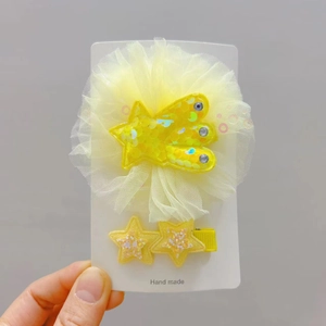 Détail d'un lot de 2 barrettes étoiles jaunes avec paillettes et décorations en tulle