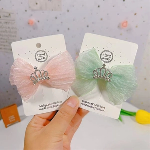 Vue détaillée des nœuds de cheveux en maille rose et vert menthe avec couronnes